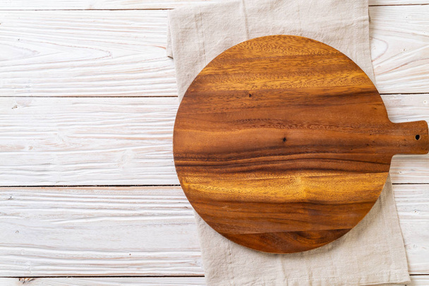 empty cutting wooden board with kitchen cloth on wood background - Foto, immagini