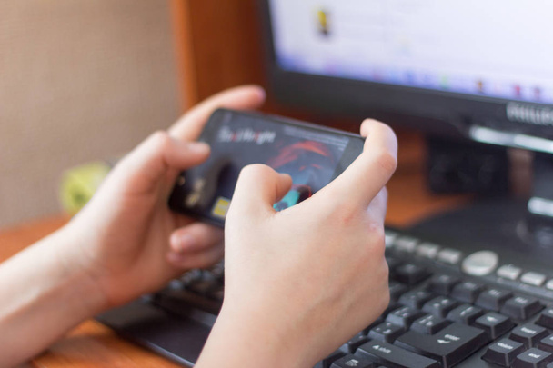 menino adolescente jogando no computador e telefone ao mesmo tempo
 - Foto, Imagem