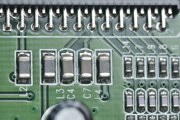 Placa eletrônica com componentes eletrônicos do circuito de computador do dispositivo close-up com uma profundidade de campo rasa
 - Foto, Imagem