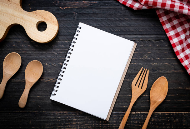 blank notebook for text note on wooden surface and wooden spoon and fork with copy sapce - Foto, afbeelding