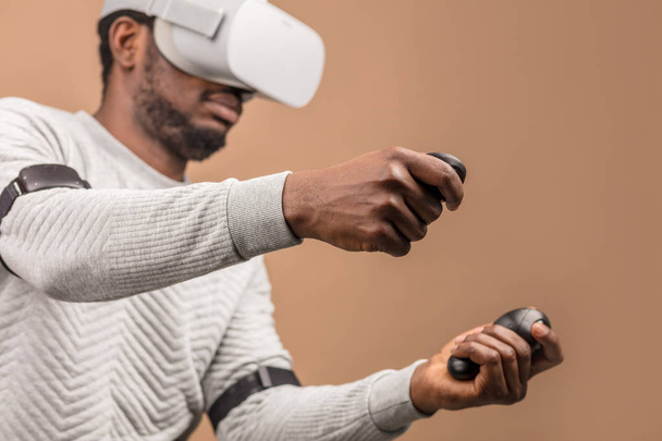 Black man wearing 3d vr glasses, playing videogame, holding joystick in hands - Foto, afbeelding