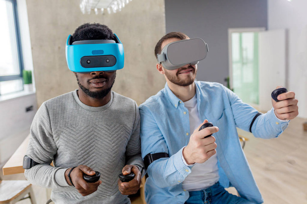 Mixed race couple of male friends develop project using virtual reality goggles - Photo, Image