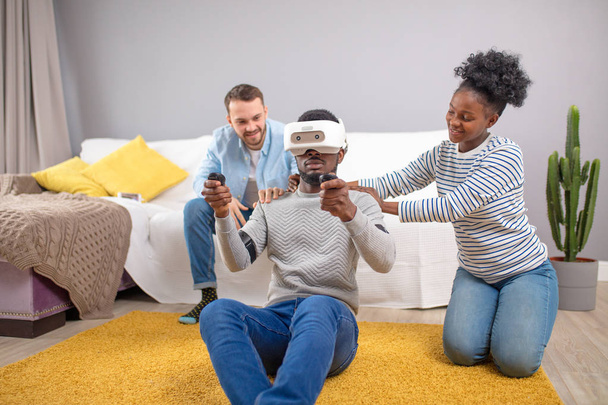 Multiracial group of friends having fun trying on 3D virtual reality goggles. - Foto, Imagen