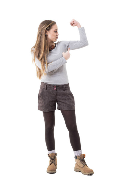 Girl Power Konzept. schlanke hübsche junge Frau, die den schlanken Arm-Bizeps-Muskel anspannt. Ganzkörper isoliert auf weißem Hintergrund.  - Foto, Bild
