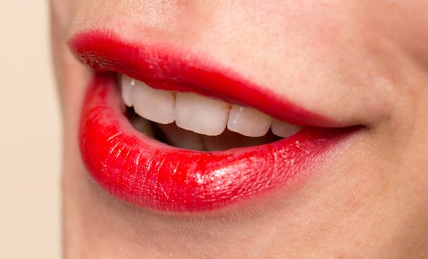 Primer plano de los labios de la mujer con lápiz labial rojo brillante
 - Foto, imagen