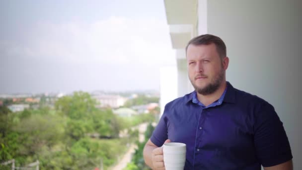 Jonge zakenman bewonderen weergave en drinken koffie staande op terras - Video