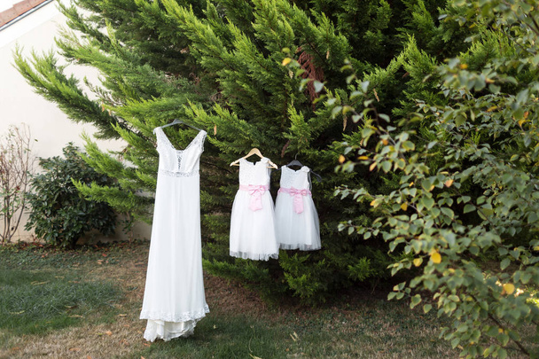 Beyaz gelinlik gelin ve köknar ağacı bahçede asılı küçük kızlar için - Fotoğraf, Görsel