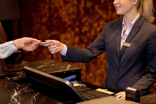 Kolay hareket, kadın otel resepsiyonunda kredi kartıyla ödeme. - Fotoğraf, Görsel