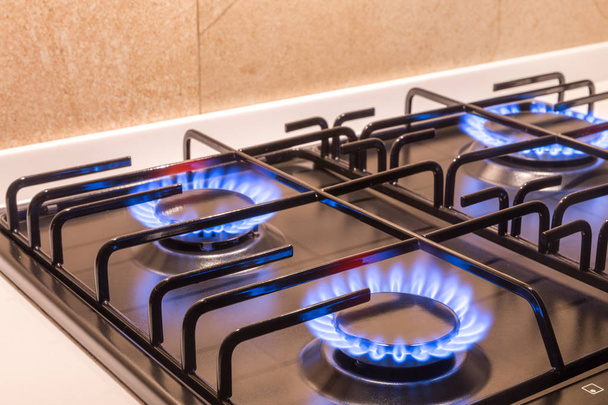 Газова конфорка на чорній сучасній кухонній плиті
 - Фото, зображення