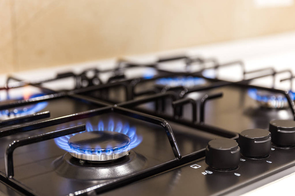 Газовая горелка на современной черной кухне
 - Фото, изображение