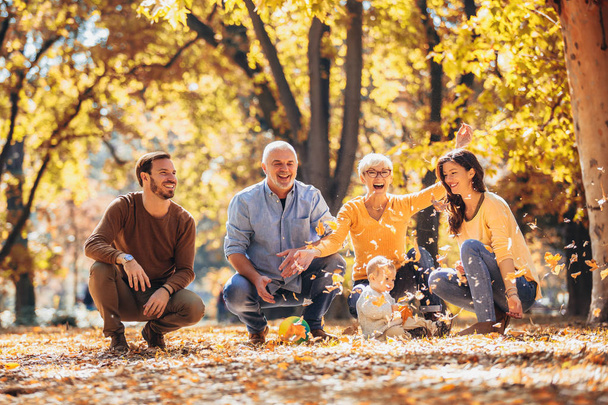 Multl generation family in autumn park having fun - Foto, Imagen