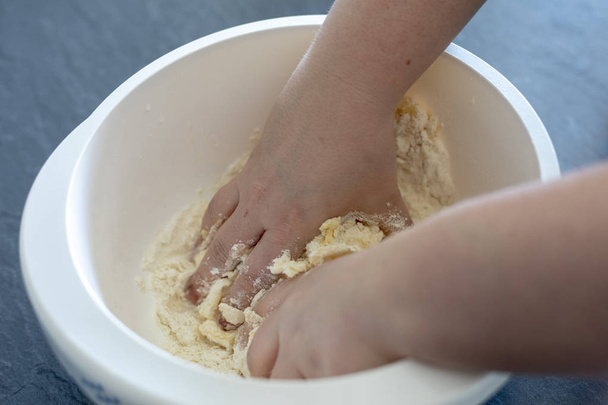 Close up of female hands preparing and knead the dough in bowl - Foto, Imagem