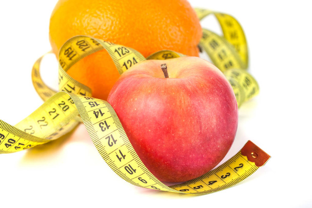 Elma ve portakal ölçü bandı beyaz arka planda, sağlıklı beslenme ile. - Fotoğraf, Görsel