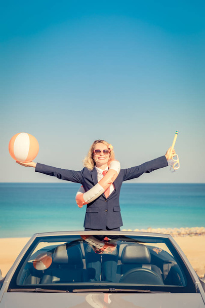 Successful young businesswoman on the beach. Woman standing in the cabriolet classic car. Summer vacations and freedom travel concept - Фото, изображение