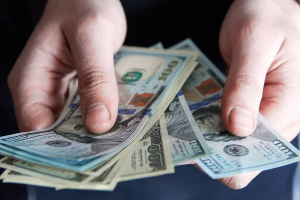 Man holdin money. Concept of savings, salary, payment and funds. Man counts cash bills - Foto, Bild