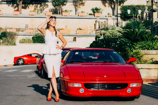 Ferrari show 8 outubro 2016 em Valletta, Malta, perto de Grand Hotel Excelsior. Menina bonita perto do Ferrari vermelho 355 FI
 - Foto, Imagem