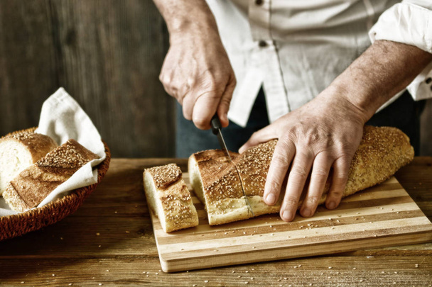 cut the bread on the wooden cutting board - eat healthy and traditional - selective focus - desaturated effect - closeup - 写真・画像