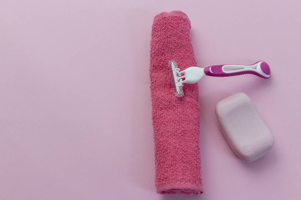 Depilation blade and towel, pink background - 写真・画像