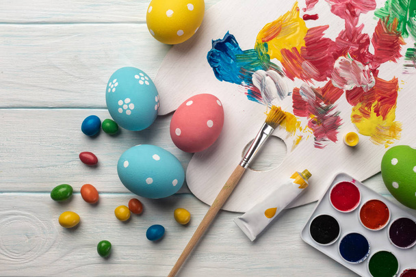 Fondo de Pascua con huevos de colores, pinturas, pinceles en gris piedra. Vista superior con espacio de copia
 - Foto, imagen