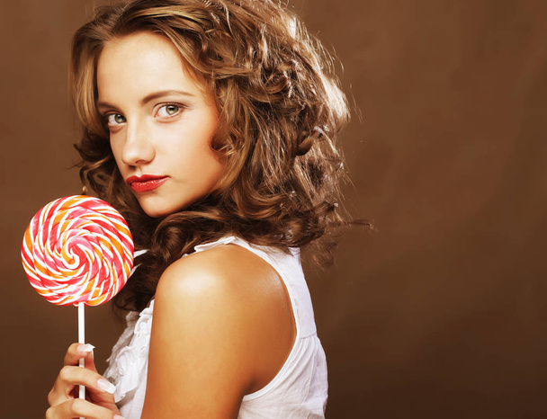 curly  girl with a lollipop in her hand  - Foto, Imagen