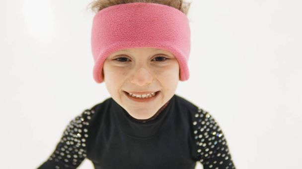 Happy little girl in rose headband in figure skating training at indoor rink - Zdjęcie, obraz