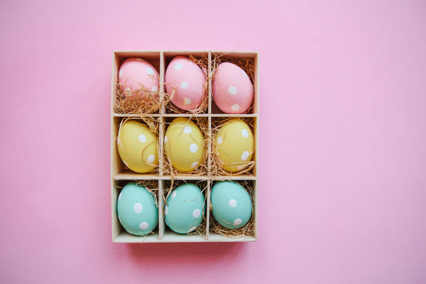 Coffret cadeau ou de vacances ou un récipient avec des œufs de Pâques colorés sur un fond rose. Concept de célébration de Pâques dans un style minimal
 - Photo, image