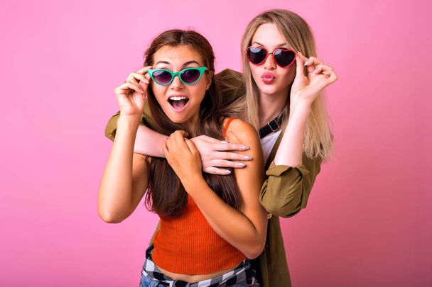Close up fashion lifestyle portrait of two young hipster girls best friends posing in studio - Foto, Imagem