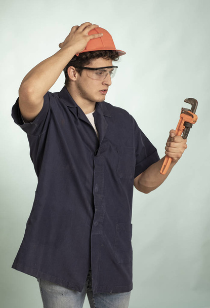 Real frustrated mechanic man detail with safety helmet on his head - Photo, Image