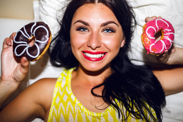 Cute  pretty woman on bed with donuts  - Фото, зображення