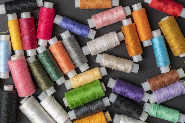 bunch of colorful sew threads lay on dark background isolated d - Foto, imagen