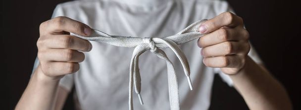 young man hold tied shoelace isolated f - Foto, afbeelding