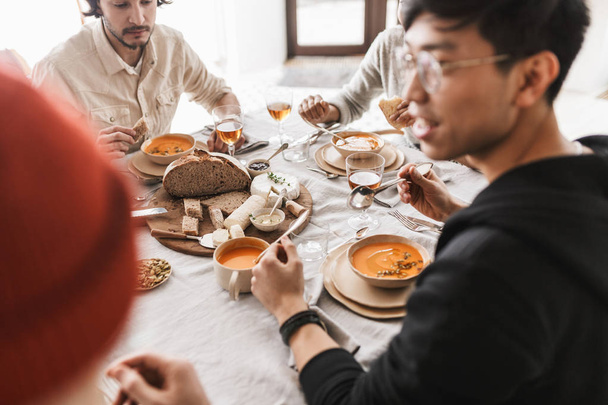 Κοντινό πλάνο φωτογραφία του tabale γεμάτα τρόφιμα. Διεθνή παρέα το γεύμα δαπάνες φορά μαζί σε cozy café - Φωτογραφία, εικόνα