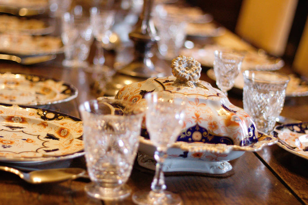 Αντίκες γυαλιά και πορσελάνης σε ένα τραπέζι στο κάστρο Scotney, Kent, Ηνωμένο Βασίλειο. - Φωτογραφία, εικόνα