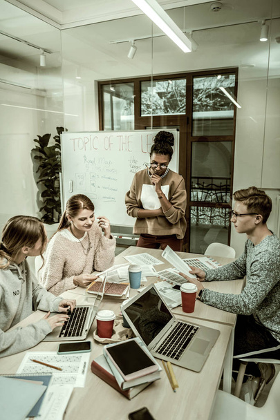Estudiantes de posgrado usando computadoras portátiles preparándose para una lluvia de ideas
 - Foto, imagen