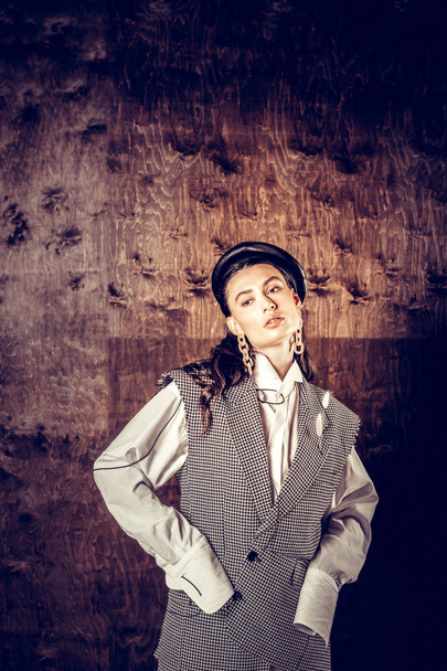 Pleasant attractive woman standing against the dark wall - Valokuva, kuva