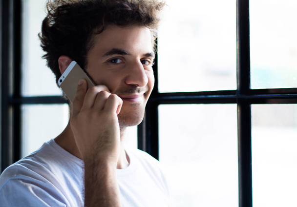 protrait of young man talking on the phone at home. - Foto, Imagen