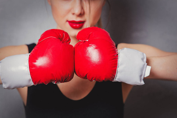 woman in boxing gloves on gray background - Foto, Imagen