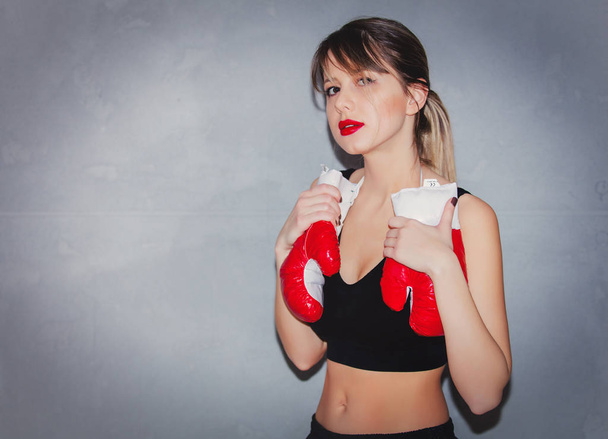 woman in boxing gloves on gray background - Photo, Image