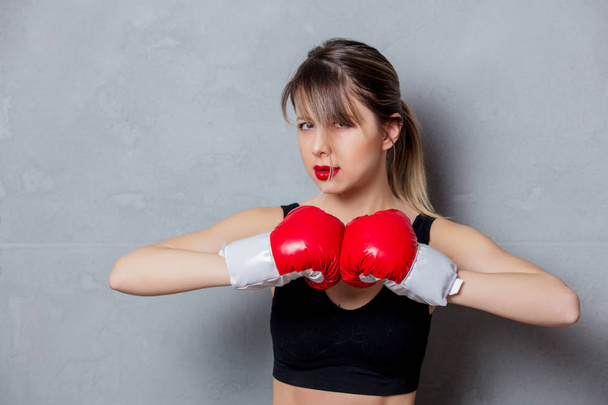 Nainen nyrkkeilyhanskat harmaalla pohjalla
 - Valokuva, kuva