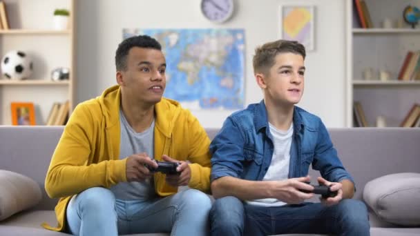 Emotional European and Afro-American friends playing video games, leisure time - Filmati, video