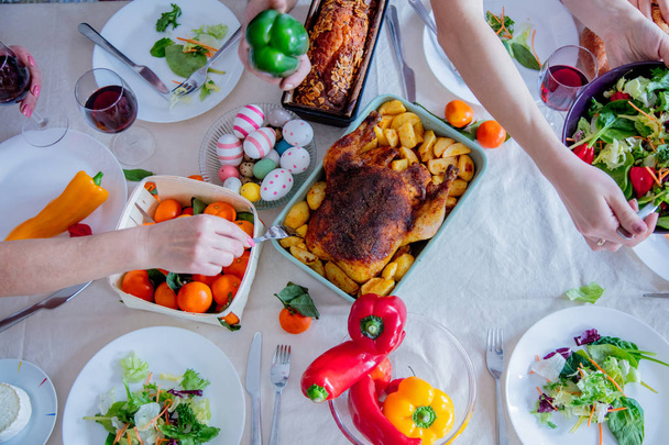 Näkymä pääsiäisenä loma pöytä ruoan kanssa. Perheen kädet
  - Valokuva, kuva