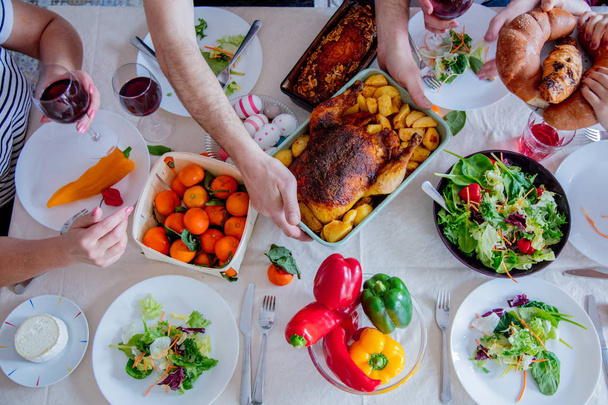Pohled na velikonoční svátek stolu s jídlem. Rodinné ruce  - Fotografie, Obrázek