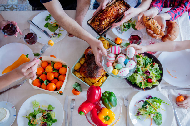Nézd meg az élelmiszer-húsvéti ünnep asztalnál. Családi kezek  - Fotó, kép