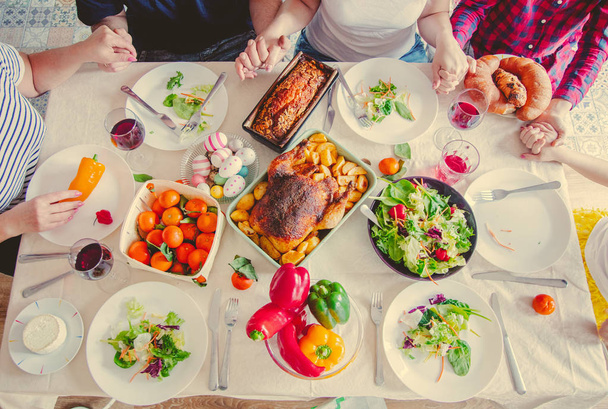 Δείτε στο πασχαλινό τραπέζι των διακοπών με το φαγητό. Οικογενειακά χέρια  - Φωτογραφία, εικόνα