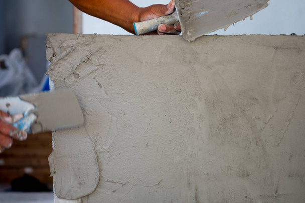 Werknemer werken handleiding met muur stukadoors tools in een huis - Foto, afbeelding