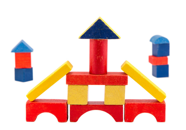 красочные деревянные игрушки кирпичной конструкции на белом
 - Фото, изображение