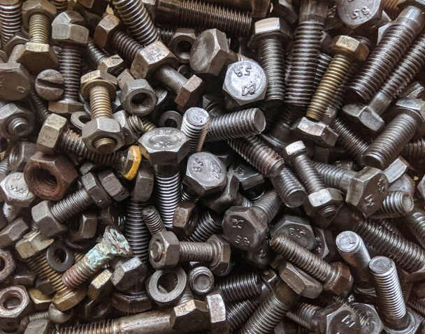 Many small and large bolts, nuts. rusty and dirty. view from above - Photo, Image