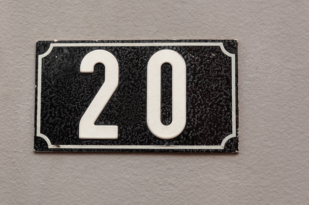 Hausnummer 20 auf Emaille-Plakette in weiß auf schwarz aus Schweden oder Paris, Frankreich - Foto, Bild