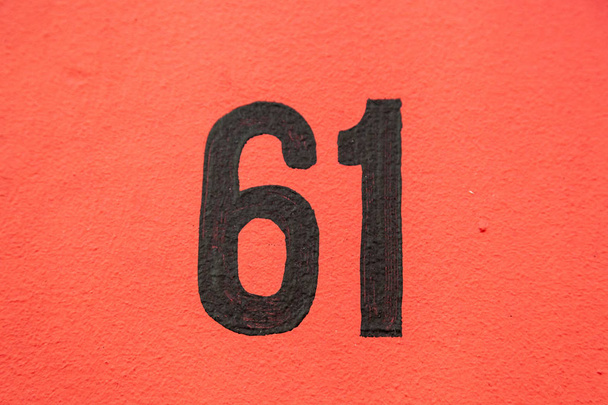 Casa número sessenta e um 61 em preto em vermelho pintado renderizado parede da casa externa na Bélgica
 - Foto, Imagem