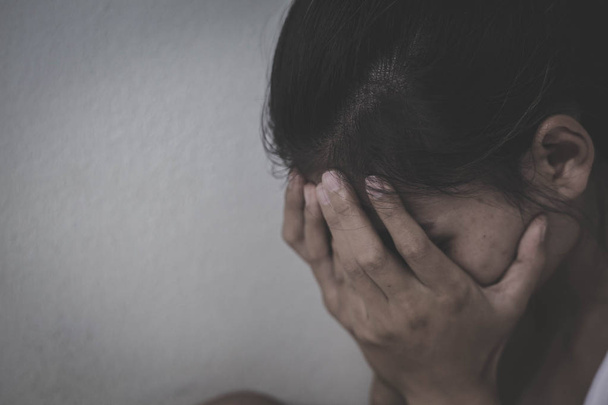 Испуганная молодая женщина, сидящая в углу своей спальни, отчаявшаяся жертва изнасилования ждет помощи, молодая депрессивная женщина, домашнее насилие и изнасилование
. - Фото, изображение